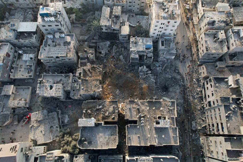 Palestinians gather at the site of Israeli strikes on houses, in Maghazi