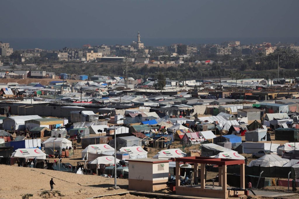 Displaced Palestinians, who fled their houses due to Israeli strikes, shelter near the border with Egypt, in Rafah in the southern Gaza Strip
