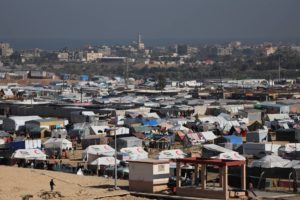 Displaced Palestinians, who fled their houses due to Israeli strikes, shelter near the border with Egypt, in Rafah in the southern Gaza Strip