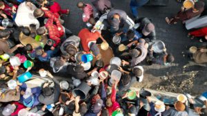 Palestinians gather to receive food cooked by a charity kitchen, in Rafah