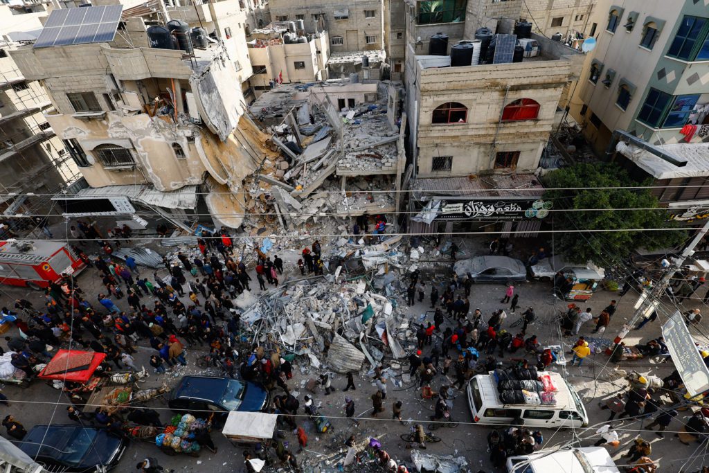 Palestinians gather at the site of an Israeli strike, in Rafah