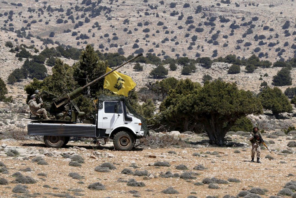 Lebanon's Hezbollah fighters rest on the back of a pick-up truck with an installed weapon in Khashaat, in the Qalamoun region after they advanced in the area