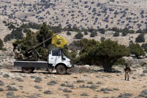 Lebanon's Hezbollah fighters rest on the back of a pick-up truck with an installed weapon in Khashaat, in the Qalamoun region after they advanced in the area