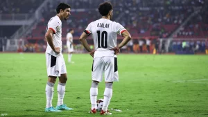 تترقب الجماهير المصرية يوم 23 فبراير المقبل، لمتابعة أول مواجهة بين النجمين محمد صلاح وعمر مرموش، الزميلين في منتخب "الفراعنة" المتنافسين في الدوري الإنجليزي الممتاز. وفي هذا اليوم، يستضيف مانشستر سيتي الذي أعلن الخميس ضم مرموش قادما من أينتراخت فرانكفورت الألماني، مع ليفربول حيث يلعب صلاح. وكان ليفربول متصدر الدوري قد تغلب على مانشستر سيتي بهدفين نظيفين في اللقاء الأول بينهما بالبطولة هذا الموسم، عندما سجل صلاح لفريقه. ومن المتوقع أن يدخل مرموش، الذي تألق بشدة في الدوري الألماني مؤخرا، دائرة النجومية في نظيره الإنجليزي سريعا، علما أنه سيكون مطالبا بمنافسة صلاح هداف "البريميرليغ" برصيد 18 هدفا، ومتصدر ترتيب التمريرات الحاسمة بواقع 13 صناعة هدف. وأعلن سيتي تعاقده مع مرموش (25 عاما)، الخميس، في خطوة توفر دعما متأخرا للمهاجم النرويجي إرلينغ هالاند. وانضم مرموش لحامل لقب الدوري الإنجليزي مقابل 70 مليون يورو وفقا لتقارير. ويتواجد النجم المصري في المركز الثاني بقائمة هدافي الدوري الألماني خلف هاري كين مهاجم بايرن ميونيخ، حيث سجل 15 هدفا في 17 مباراة مع فرانكفورت هذا الموسم. ويشكل الانتقال تتويجا سريعا لتطور مرموش، الذي تعاقد مع فرانكفورت في صفقة انتقال حر عام 2023 قادما من فولفسبورغ، حيث سجل 5 أهداف فقط في الموسم السابق. ولم يتضح بعد كيف سيتأقلم مرموش مع طريقة لعب المدير الفني لمانشستر سيتي جوسيب غوارديولا، وكان أفضل أداء قدمه عندما لعب في خطة تعتمد على الدفع بمهاجمين اثنين، حيث كان يلعب بجوار هوغو إيكيتيكي، مهاجم باريس سان جرمان الفرنسي السابق، لكن "بيب" يفضل الاعتماد على مهاجم واحد هو هالاند. وبإمكان مرموش اللعب على الأجناب، ولعب في هذه المراكز مع منتخب مصر، لكنه لا يحقق نفس النجاح الذي يحققه عندما يلعب في المنتصف. وسجل مرموش 6 أهداف وصنع 3 في 35 مباراة شارك بها مع "الفراعنة".