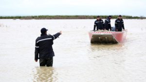 لم يكن أهالي قرية لكفيفات غربي المغرب يتوقعون أن تتحول منطقتهم إلى جزيرة معزولة، جراء الفيضانات الاستثنائية التي اجتاحت أربعة أقاليم في المملكة. لكفيفات التابعة لإقليم القنيطرة، كانت قبل أسابيع قليلة تعاني موجة جفاف، بعد نفاد مخزون المياه من الآبار، وهذا ما أثار حفيظة الأهالي بعد أن تحولت مؤخرا إلى جزيرة معزولة. عائلات كثيرة في القرية، غادرت منازلها المغمورة بالمياه تجاه مخيم الهماميس الذي شيدته السلطات في ضواحي القنيطرة، والذي يبعد نحو 22 كيلومترا عنها، بسبب صعوبة التأقلم مع هذه الظروف غير المسبوقة. بينما آثرت عائلات أخرى البقاء في القرية وسط انقطاع تام للماء والكهرباء، وضعف كبير في شبكة الإنترنت، لتعيش أوضاعا متفاقمة وغير مسبوقة. وبين 28 يناير/كانون الثاني الماضي، و14 فبراير/شباط الحالي، شهدت أقاليم القنيطرة، والعرائش وسيدي قاسم وسيدي سليمان (شمال)، فيضانات بعدة مدن، خاصة في مدينة القصر الكبير التابعة لإقليم العرائش، إثر امتلاء سد "واد المخازن" ليصل إلى 156% من سعته للمرة الأولى، ما أدى إلى فيضانه. ولا تزال المياه تعزل عدة قرى مثل المكرد بالقنيطرة، والحوافات بسيدي سليمان، وسط مخاطر من تفريغ حمولات مياه السدود مثل سد "واد المخازن"، وفق مراسل الأناضول. وقررت الحكومة تخصيص 300 مليون دولار لدعم المناطق المتضررة من الفيضانات التي أدت إلى مصرع 4 أشخاص، وفقدان واحد، وإجلاء نحو 188 ألف شخص من الأقاليم الأربعة، بعدما اجتاحت أكثر من 110 آلاف هكتار. المياه تجاوزت مترين في قرية لكفيفات الأناضول رافقت أحد قوارب الإجلاء من قرية لكفيفات، واطلعت على مخاطر الرحلة، والأوضاع المتفاقمة هناك، كما حاورت بعضا من أهالي القرية. المياه تطوق لكفيفات من كل مكان، ويصل مستواها بجهتها الجنوبية إلى نحو مترين، ولحسن حظ بعض المنازل أنها في أماكن مرتفعة قليلا. وخصص جهاز الوقاية المدنية (الدفاع المدني) قوارب لنقل من يريد التوجه إلى مخيم الهماميس، فضلا عن عمليات تمشيط لهذه القرية وما جاورها، بحثا عن نداءات استغاثة أو ارتفاع جديد لمستوى المياه. وتنطلق مركبات الوقاية المدنية لمسافة تزيد عن 20 كلم مغمورة بالمياه للوصول إلى لكفيفات، بغرض مساعدة الأهالي وحمل حاجاتهم الضرورية قبل إجلائهم. وعلى طول المسافة تُرى منازل وهي مغمورة بالمياه، ولا يظهر من الشارع الذي يوجد على مشارف القرية إلا أعمدة الكهرباء، وبمجرد رؤية أهالي القرية للمركب انطلقوا بالهتافات المرحبة، حيث أبحر ربان المركب إلى العمق قليلا، فلاحت له مؤسسة تعليمية مغمورة بالمياه. وإلى جانب لكفيفات، توجد بعض القرى المجاورة التي غمرتها المياه، مثل المكرن وديور الصوفر والقطعات. المنزل غمر بالكامل المواطن سفيان المحكاك (35 سنة)، أحد سكان لكفيفات، ينتظر بفارغ الصبر تحسن أحوال الطقس ليتراجع مستوى المياه بالقرية. وفي حديث للأناضول، يعرب المحكاك عن حزنه الشديد لما وصلت إليه الأوضاع في القرية وسط غياب الماء والكهرباء، وانقطاع الاتصالات. وفي حسرة ظهرت على وجهه، يضيف أن المياه غمرت منزله بالكامل، "حيث تعطل المكان وتوقف الزمن". ويؤكد أن المياه حاصرت القرية من كل مكان، ونفد مخزون الغذاء بعد دخول الفيضانات أسبوعها الثاني. وعن أوضاع من تبقى بالقرية، يقول المحكاك إن بعض الأسر خائفة من أن تترك ممتلكاتها، وأخرى لا تود أن تترك ماشيتها، داعيا السلطات إلى دعم العائلات التي اختارت البقاء. تضامن بالقرية ووسط هذه الأوضاع المتفاقمة، يسود تضامن كبير بين العائلات في القرية. ويقول محمد الشكير (40 سنة) إن هناك تضامنا كبيرا بين العائلات، حيث يتقاسمون ما لديهم من منتجات غذائية. وفي حديث للأناضول، يشير الشكير إلى أن الأسر التي بقيت بالقرية، اتخذت قرارها بسبب الخوف على ماشيتها. فيضانات في سيدي سليمان، شمال غرب المغرب، 13 فبراير 2026 (فرانس برس) الشكير يدعو إلى ضرورة دعم أهالي القرية بسبب ما ألم بهم، "فهذا أمر من الله، ولا مفر من ذلك". وخلال العودة، تحركت 4 مراكب تحمل مواطنين إلى المخيمات، بينهم سيدة برفقة أطفالها الصغار، وهي تغطيهم بقطعة كبيرة من البلاستيك. رحلة العودة تزامنت مع أمطار ورياح قوية، ما جعل الماء يتدفق على المراكب، وسط حالة قلق خيمت على الأجواء. والجمعة، أعلنت الحكومة المغربية عزمها صرف 140 ألف درهم (14 ألف دولار) لكل منزل انهار جراء الفيضانات التي اجتاحت الأقاليم الأربعة، فضلا عن 6000 درهم (600 دولار) لكل عائلة متضررة. ووفق بيان لرئاسة الحكومة: "ستتم مواكبة الفلاحين المتضررين، من خلال إطلاق برنامج يتلاءم مع خصوصيات المناطق المتضررة، عبر دعم اقتناء البذور والأسمدة، لتسريع وتيرة استدراك الموسم". والأحد، بدأت عودة المتضررين الذين أخلوا منازلهم تدريجيا، مع تحسن الأحوال الجوية. وقالت وزارة الماء في بيان، إنها تعتزم اتخاذ التدابير الرامية إلى ضمان عودة آمنة وتدريجية للسكان الذين سبق إجلاؤهم من الأقاليم الأربعة.